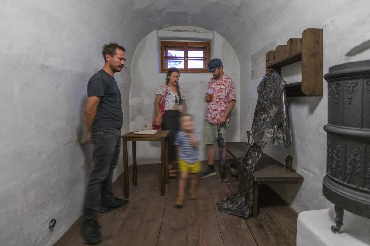Instalace v cele — objekt z kamene a oděv, výstava Hortus saxorum